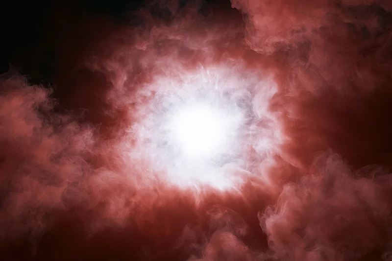 Bright white glowing orb surrounded by billowing red smoke against dark background