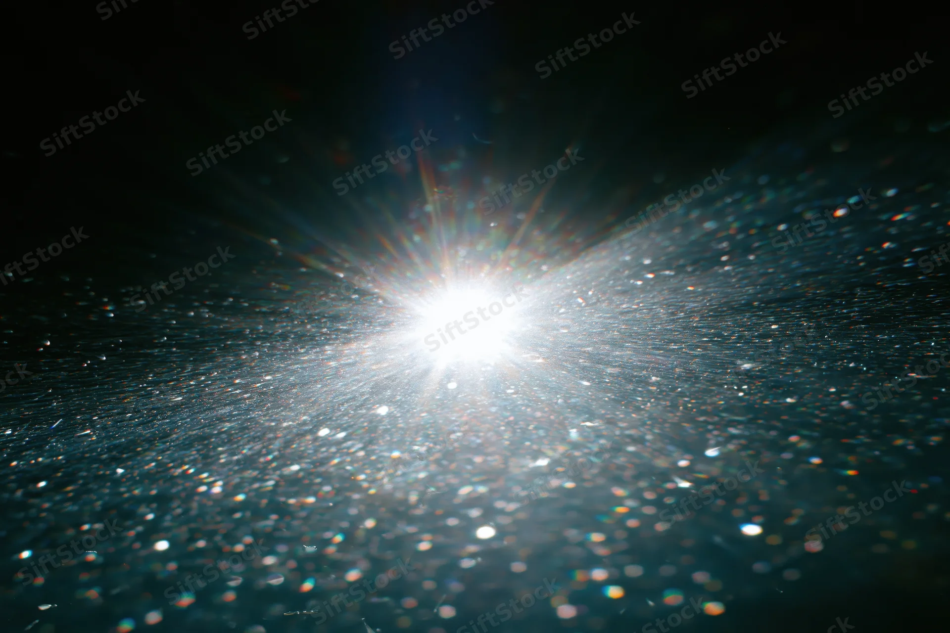 Bright white light bursting underwater with sparkling particles and lens flare