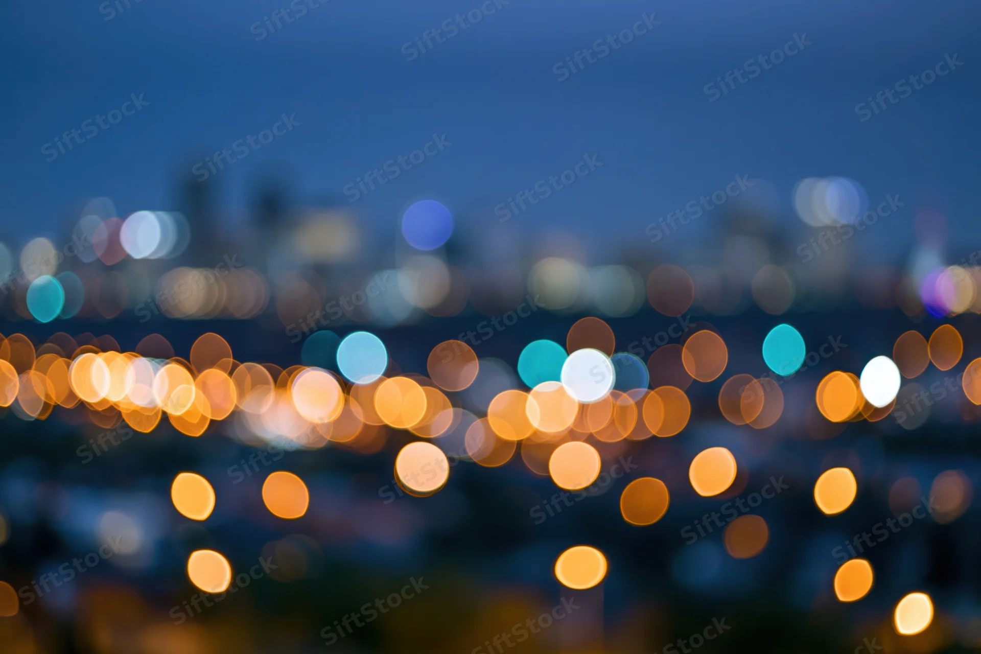 Blurred city lights at night forming circular bokeh patterns across the skyline