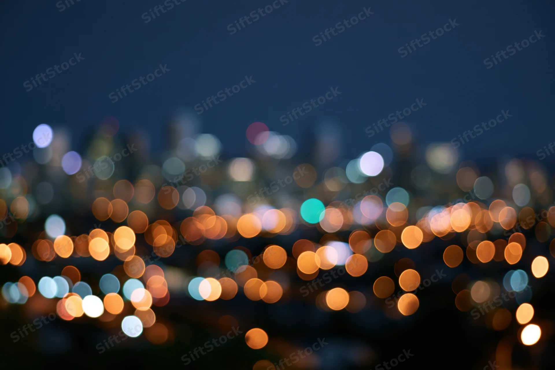 Blurred city lights at night forming circular bokeh patterns across the skyline