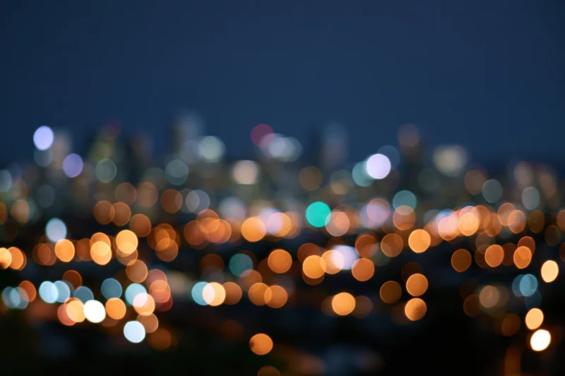 Blurred city lights at night forming circular bokeh patterns across the skyline