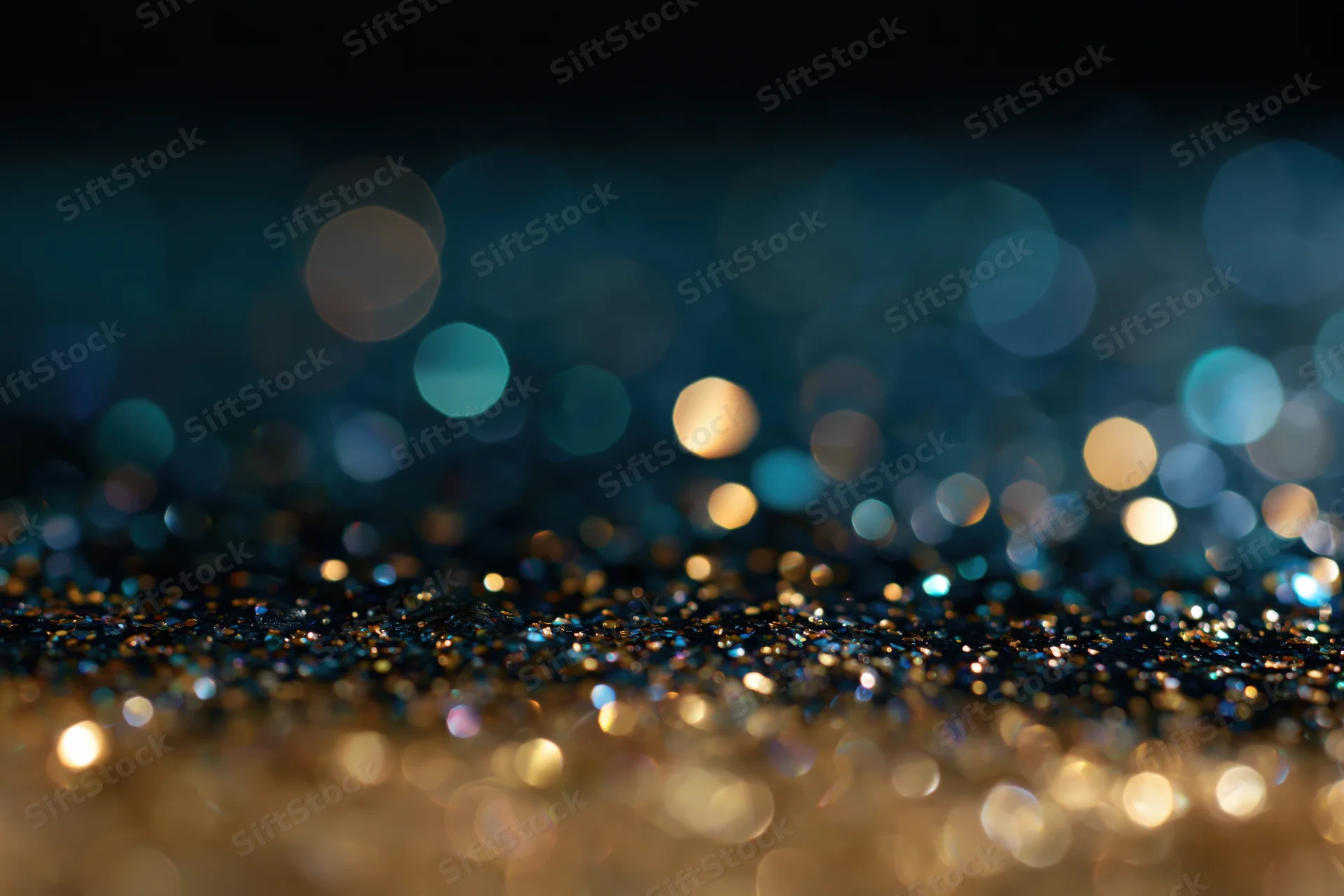 Scattered glitter with bokeh lights on dark surface