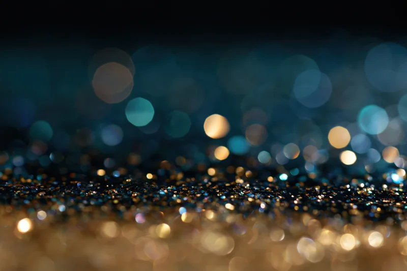 Scattered glitter with bokeh lights on dark surface
