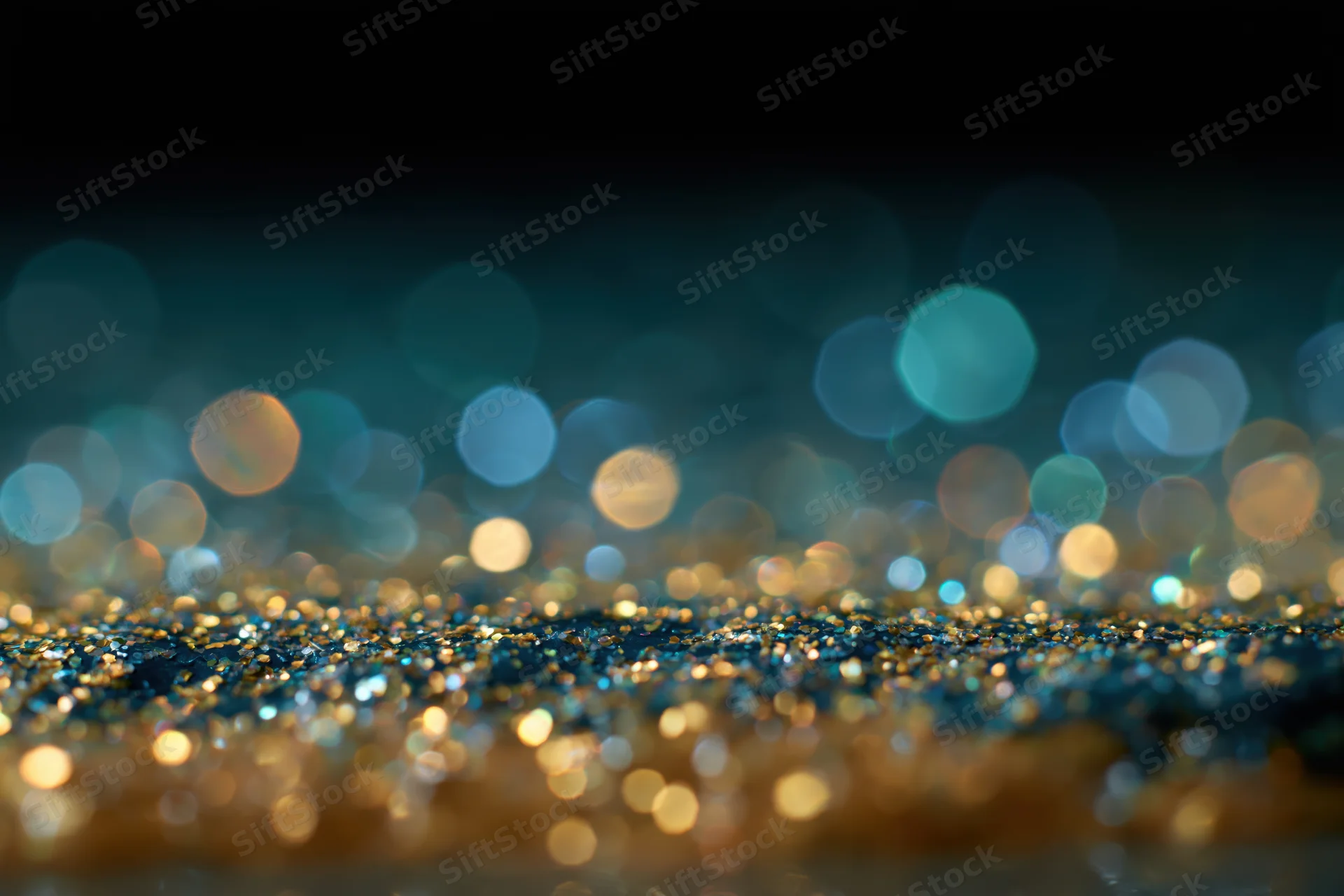 Scattered glitter with out-of-focus bokeh lights on a dark surface
