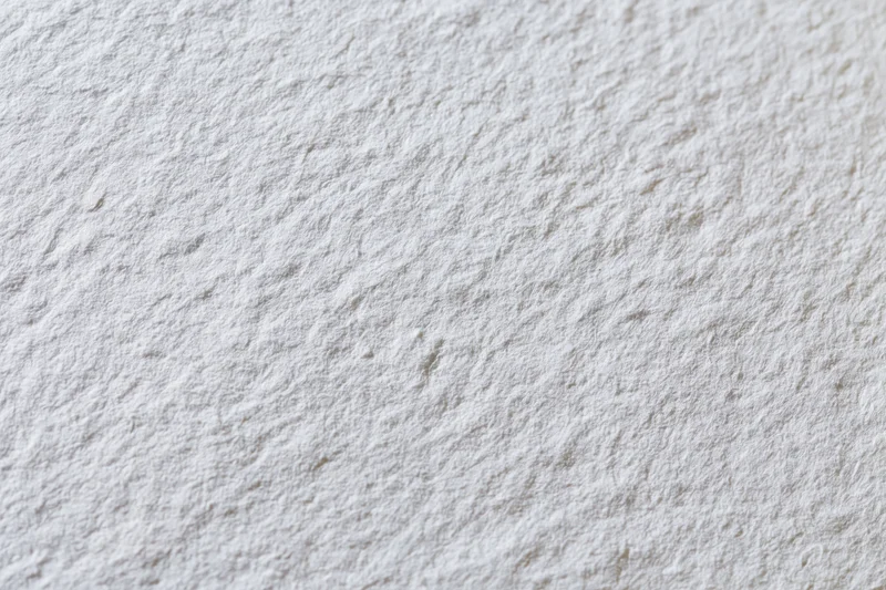 Close-up flat lay of a blank white watercolor paper sheet showing textured surface