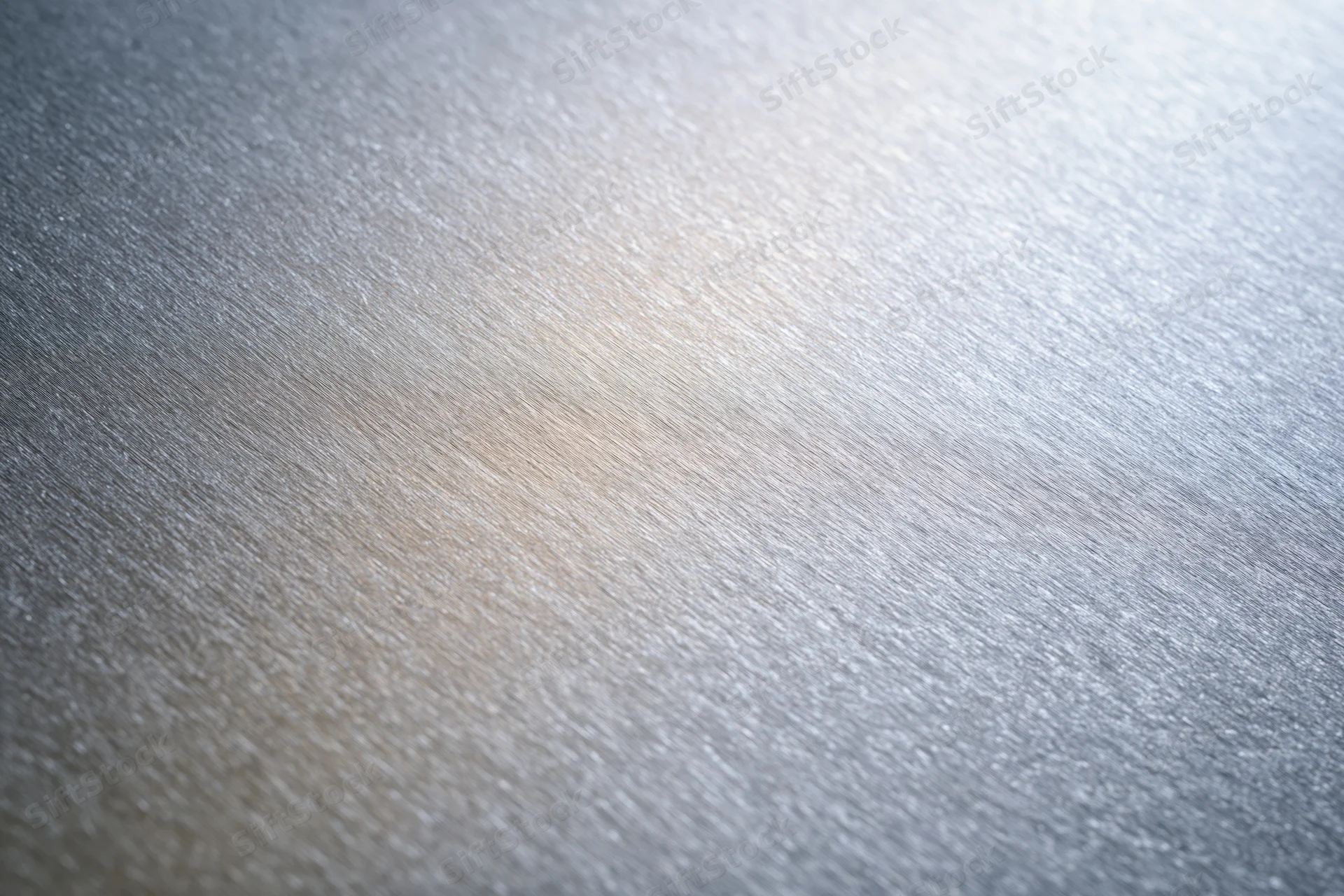 Close-up of brushed aluminum surface with linear texture and metallic sheen