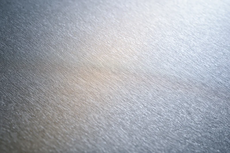 Close-up of brushed aluminum surface with linear texture and metallic sheen