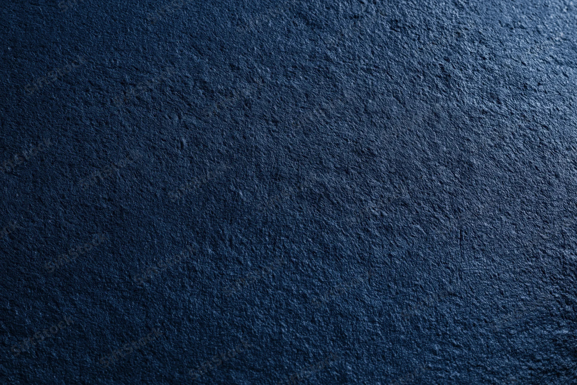 Close-up flat lay of dark navy blue textured concrete surface