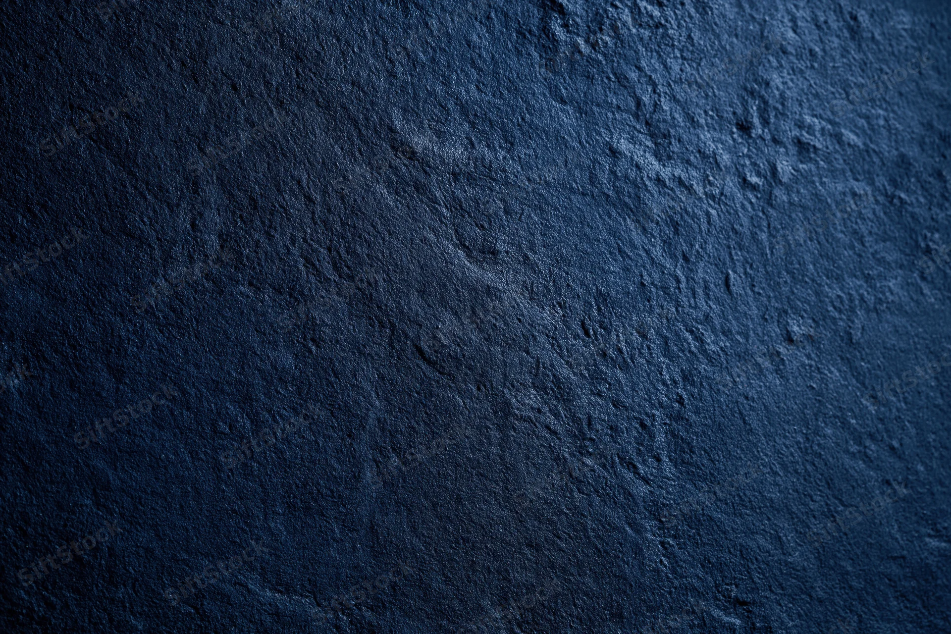 Dark navy blue textured concrete surface in close-up flat lay view