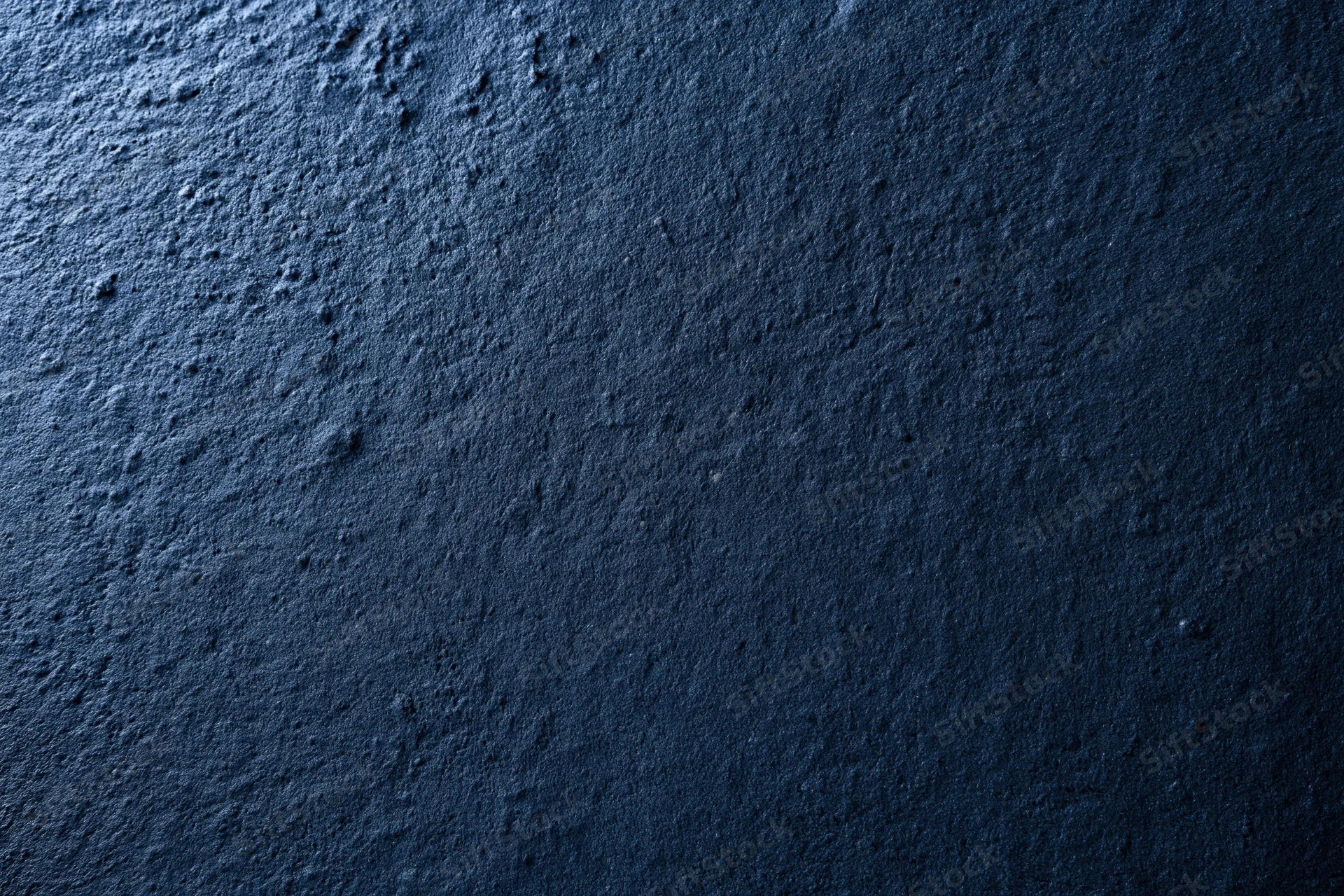 Close-up flat lay of dark navy blue textured concrete surface