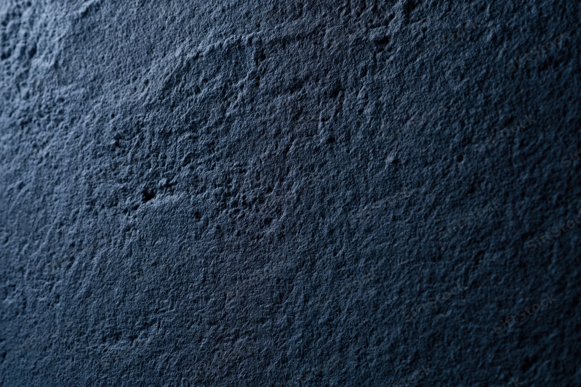 Close-up of dark navy blue textured concrete surface in flat lay arrangement