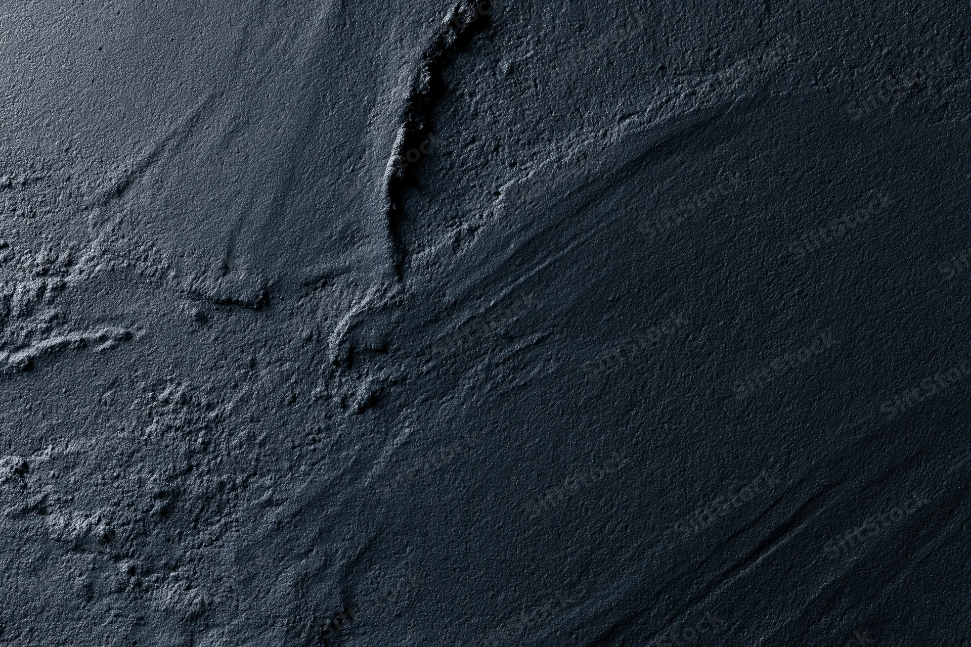 Dark textured concrete wall with cracks and seams in close-up flat lay