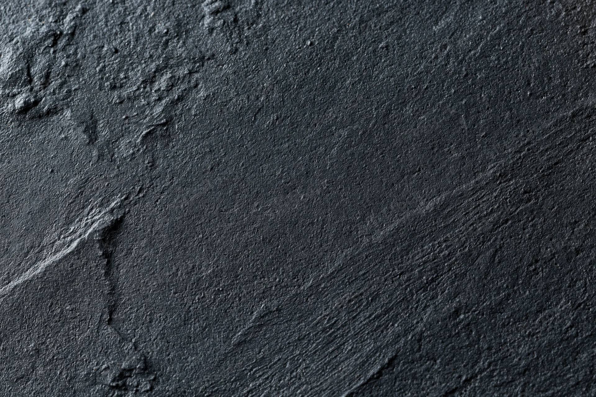 Dark textured concrete wall surface in close-up flat lay view