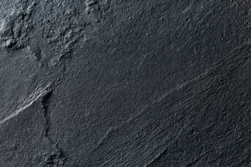 Dark textured concrete wall surface in close-up flat lay view