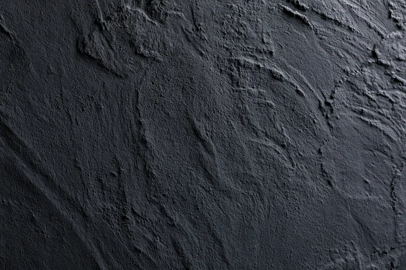 Dark textured concrete wall in close-up flat lay view