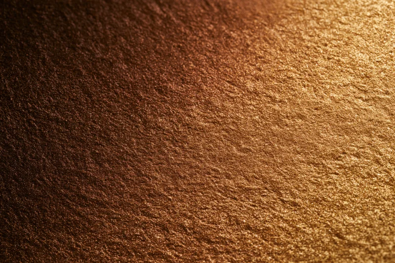 Close-up flat lay of a gold glitter-coated surface filling the frame with shimmering texture and reflective sparkle