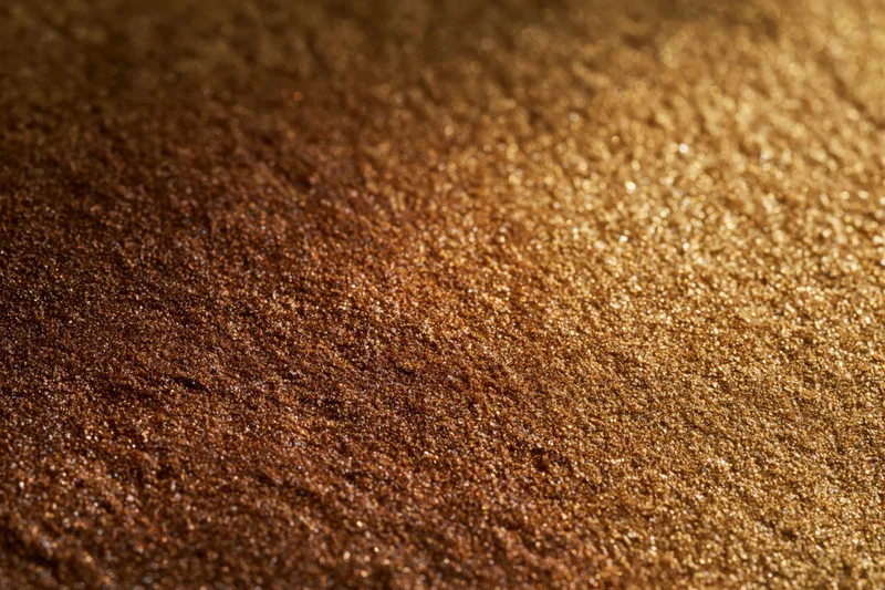 Gold glitter surface in close-up flat lay with warm gradient and sparkle