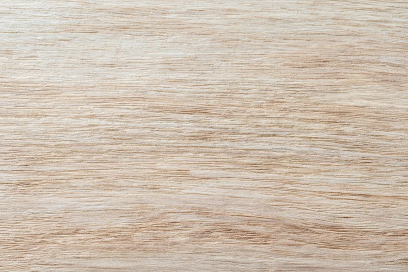 Close-up flat lay of a light bleached wood surface filling the frame with visible grain pattern