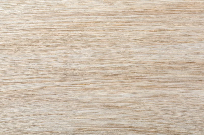 Close-up flat lay of a light bleached wood surface filling the frame with horizontal grain pattern