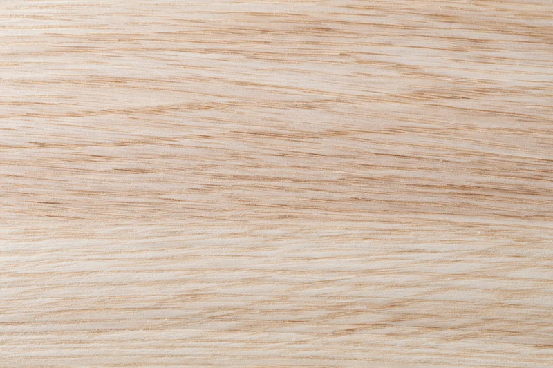 Close-up flat lay of a light natural wood surface with fine straight grain pattern