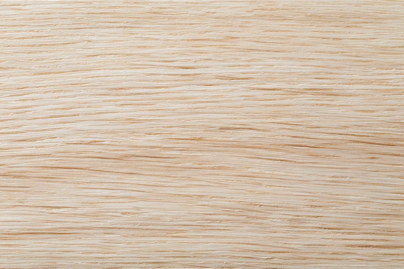 Close-up flat lay of a light natural wood surface with fine horizontal grain pattern