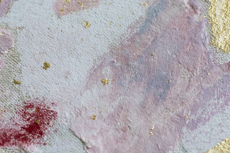 Close-up of layered abstract paint on linen canvas with gold accents and textured surface
