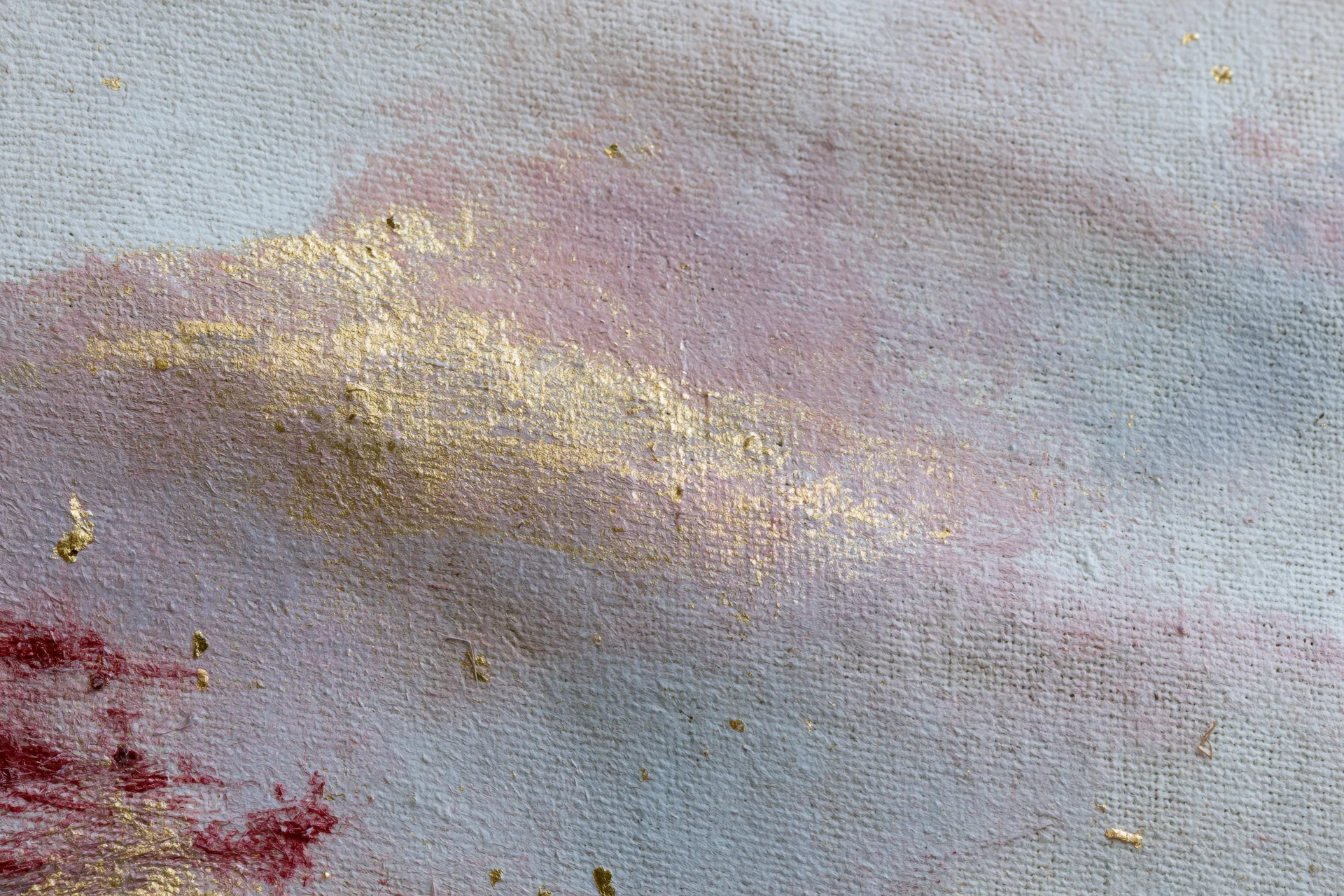 Close-up of layered abstract paint on linen canvas with gold and red accents