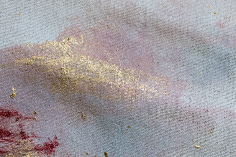 Close-up of layered abstract paint on linen canvas with gold and red accents