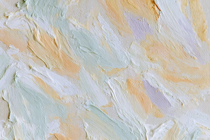 Close-up of textured paint strokes on canvas surface in soft pastel tones
