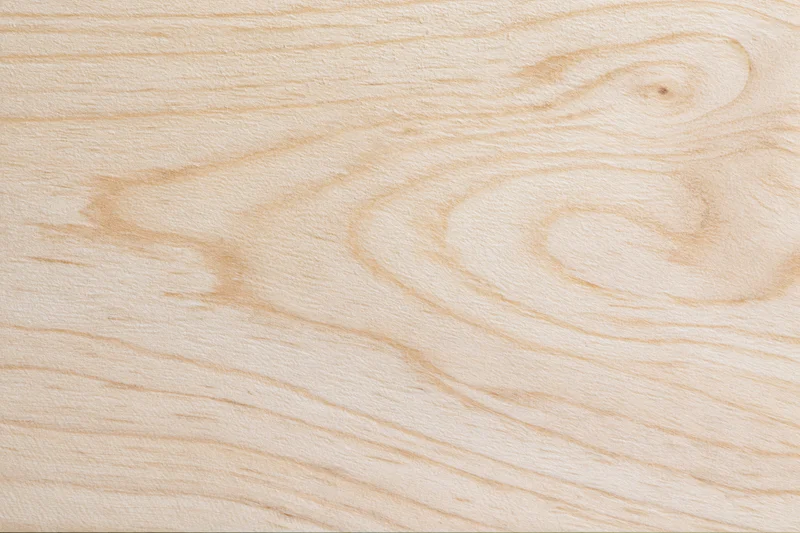Close-up flat lay of a pale birch wood surface filling the frame