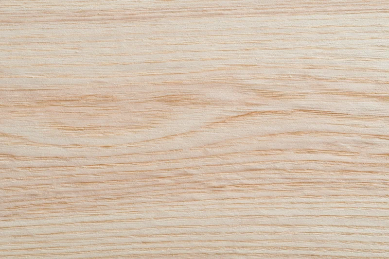Close-up flat lay of a pale bleached wood surface filling the frame
