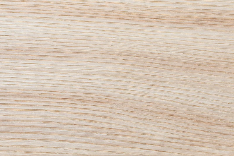 Close-up flat lay of a pale bleached wood surface filling the frame