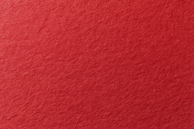 Close-up flat lay of red cardstock surface showing texture and grain