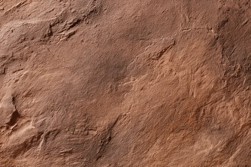 Close-up of rough stucco wall surface with textured finish