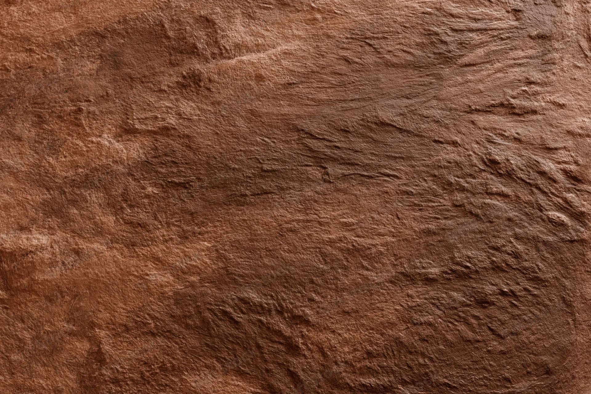 Close-up of rough stucco wall surface with textured brown finish