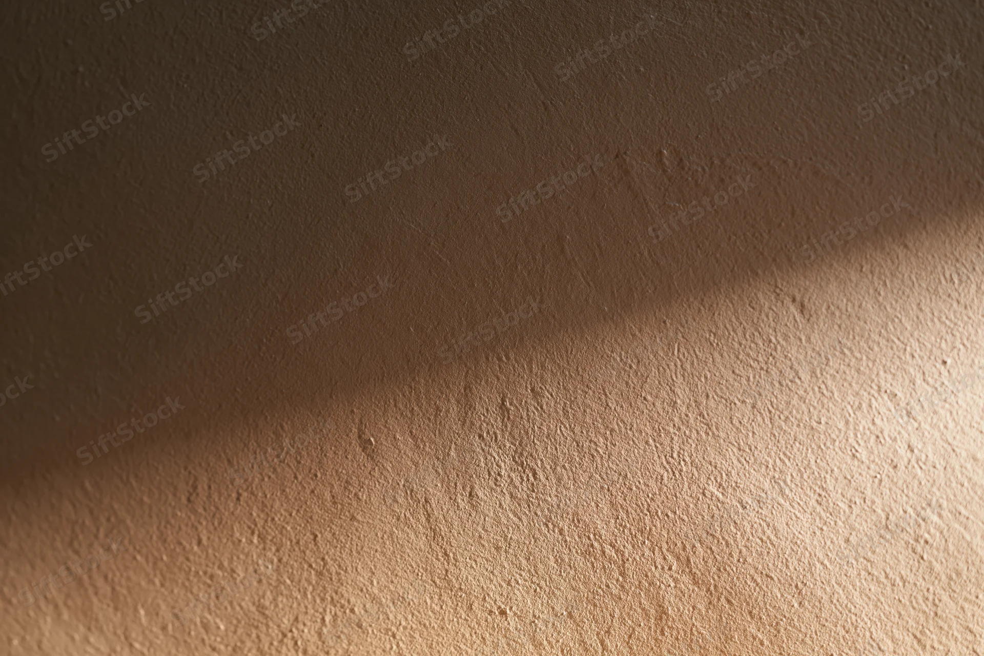 Close-up of a smooth plastered wall surface with soft lighting and shadow gradient in an indoor setting