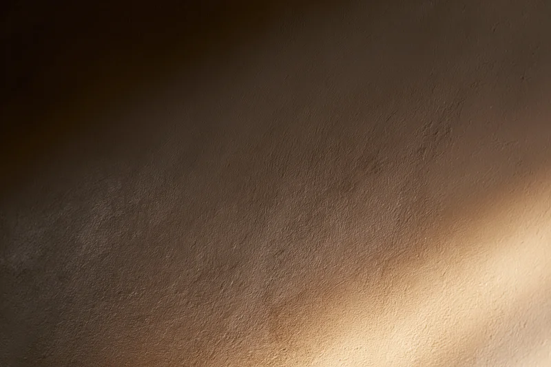 Close-up of a smooth plastered wall surface with soft light and shadow gradient