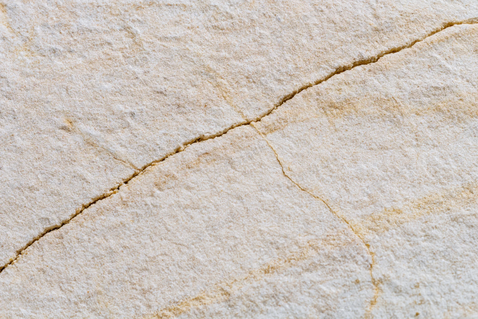 Close-up of a smooth sandstone surface with natural cracks and texture