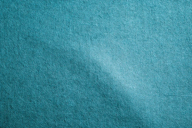 Teal-turquoise fabric surface in flat lay closeup filling frame