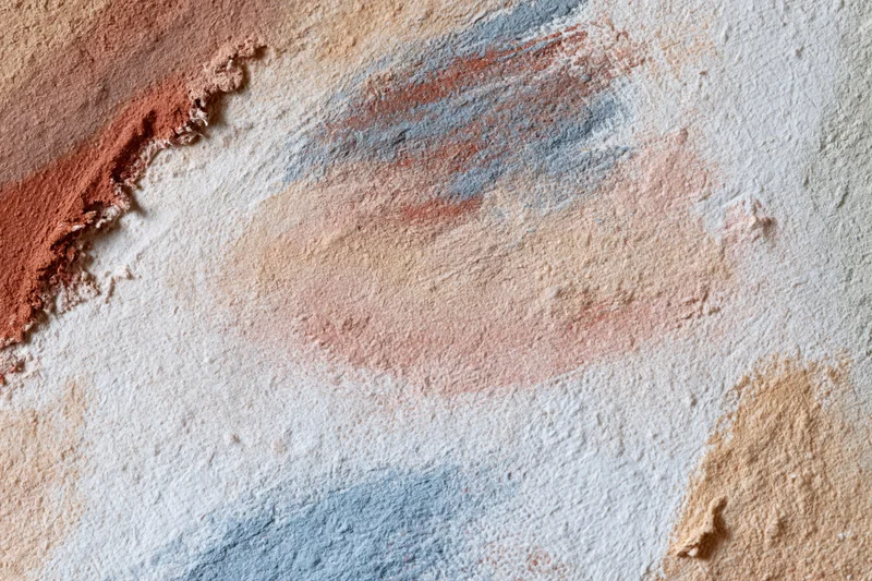 Textured painted canvas surface with layered brushstrokes and blended colors in a flat lay arrangement