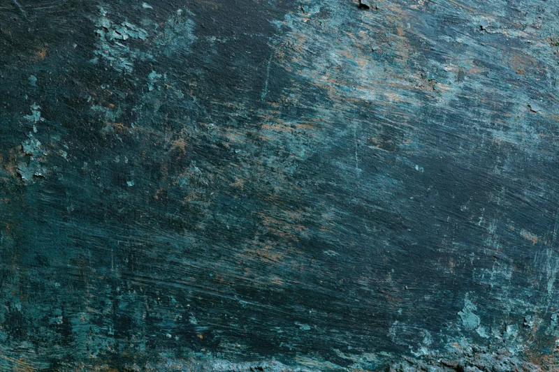 Close-up of a weathered painted metal surface showing peeling blue paint and rust streaks