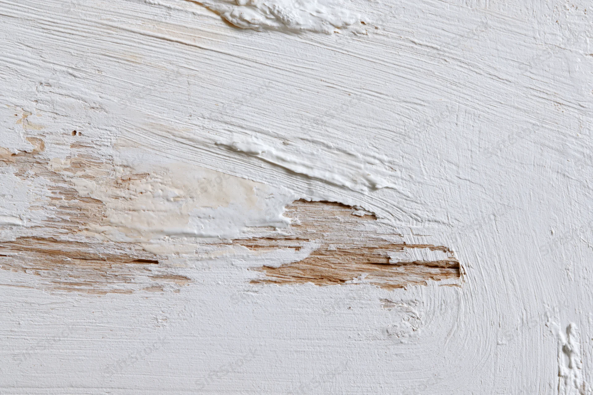 Weathered wooden surface with peeling white paint showing natural wood grain