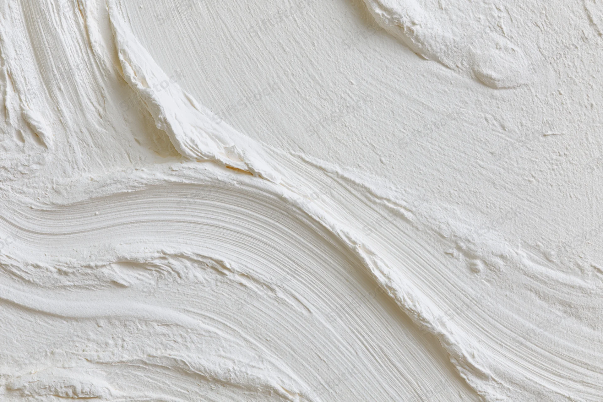 Close-up of white textured wall surface with visible brushstroke sweep