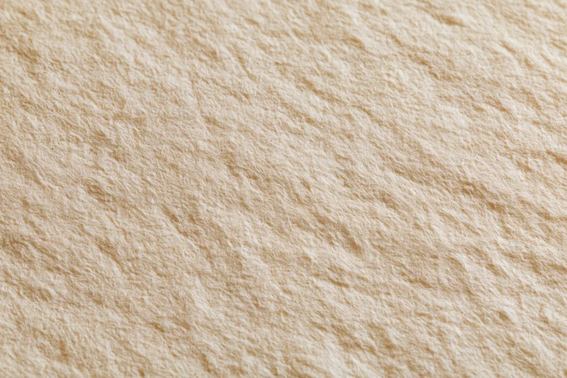 Close-up flat lay of aged cream paper surface with slight texture