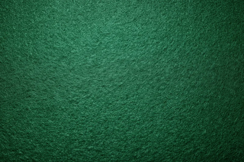 Green casino felt fabric filling the frame in a flat lay close-up