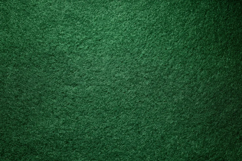 Green casino felt fabric filling the frame in a flat lay close-up view