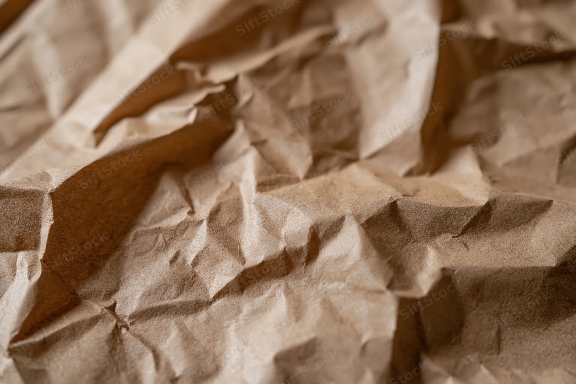 Crumpled brown kraft paper surface in close-up flat lay arrangement