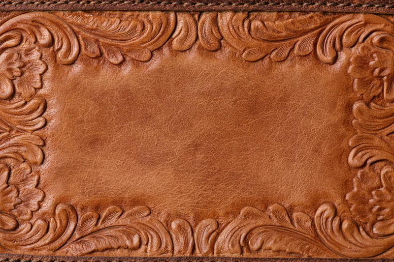 Tooled leather surface with embossed floral border in flat lay arrangement