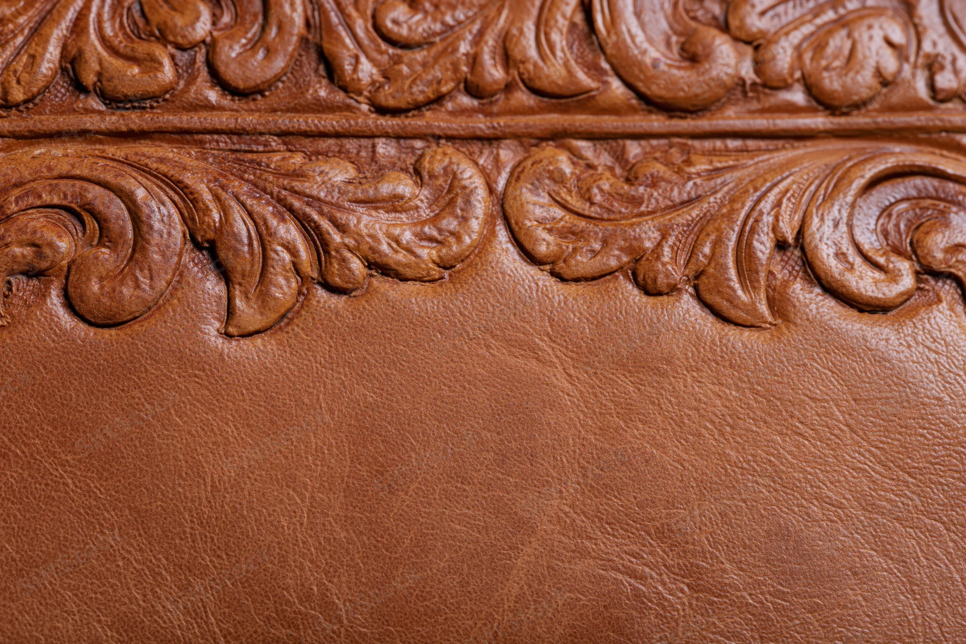 Tooled leather surface with embossed floral pattern in flat lay arrangement