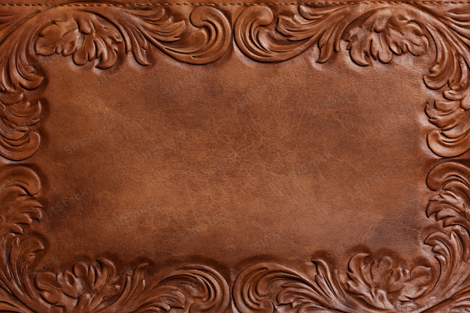 Tooled leather surface with embossed floral border in flat lay arrangement